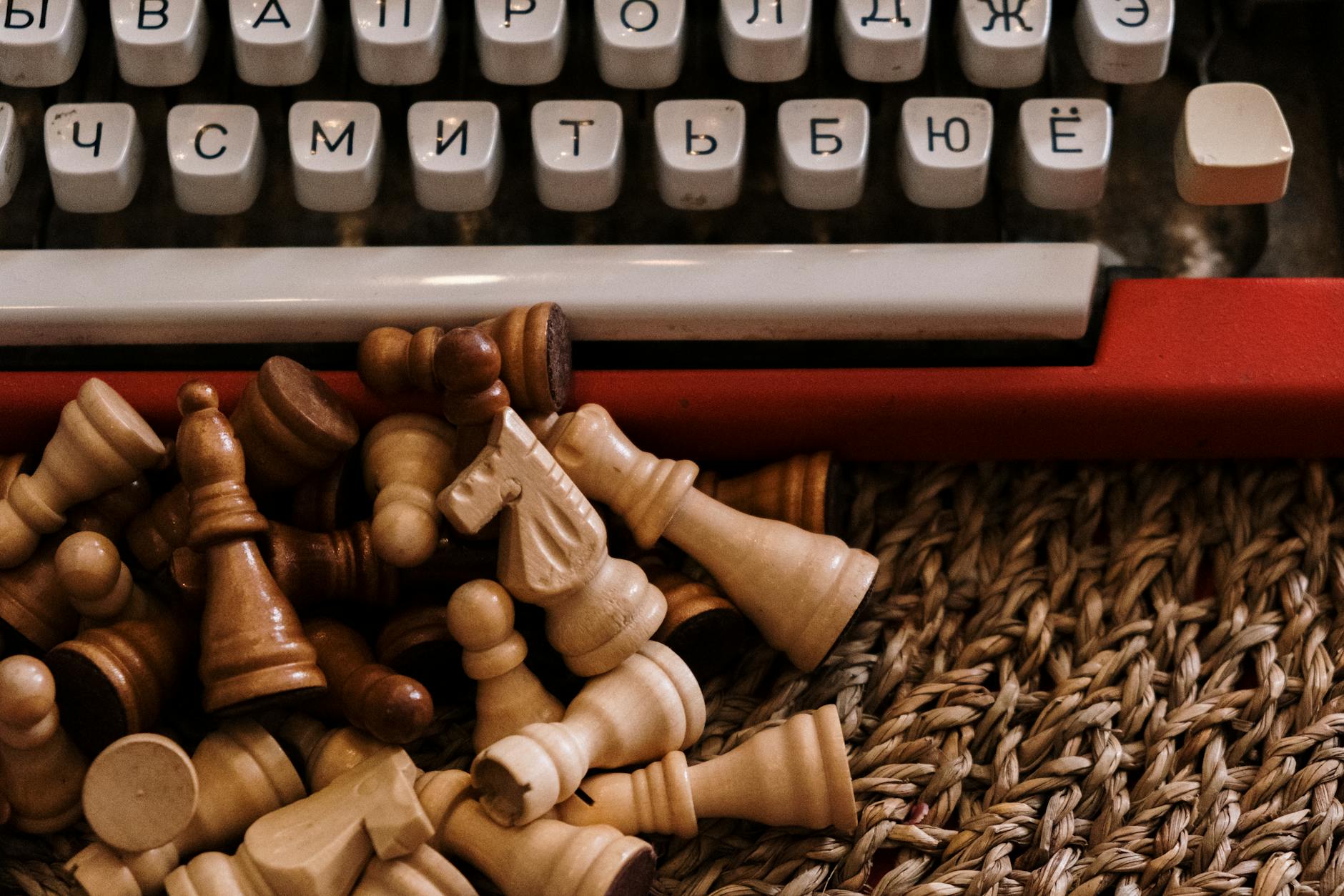 chess pieces near typewriter keyboard